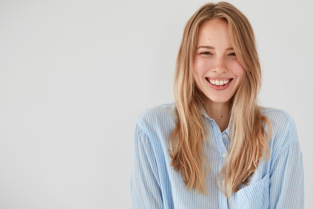 chica rubia camisa azul sonriente