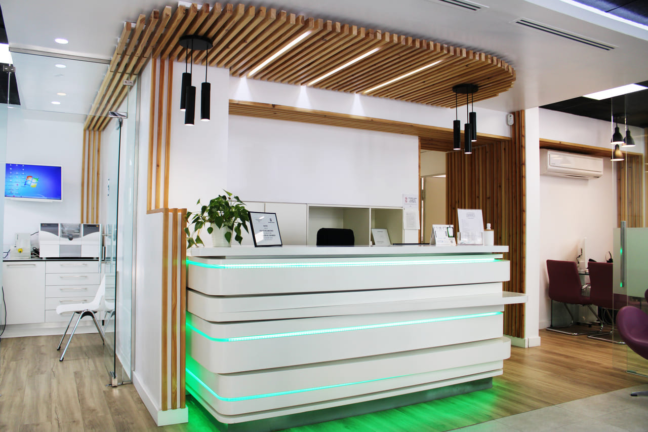 garantia dental barrio quintana madrid recepcion clinica dental con iluminacion led verde y mostrador moderno