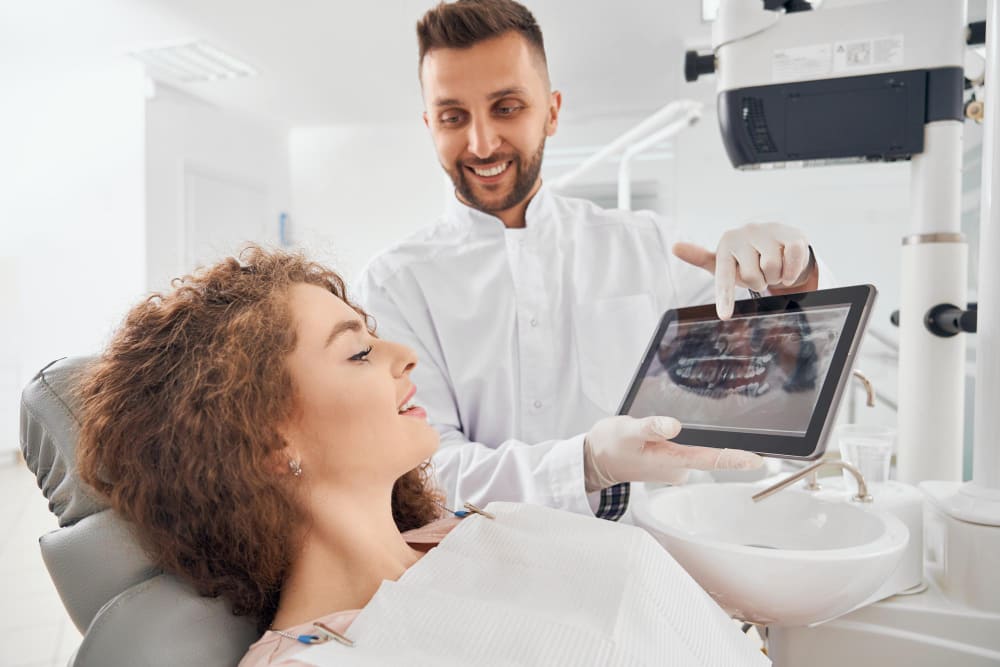medico masculino que muestra imagenes rayos x dientes tableta