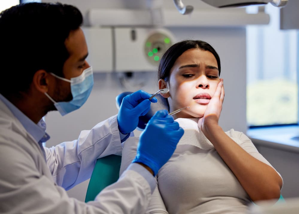 mujer con dolor consulta con dentista